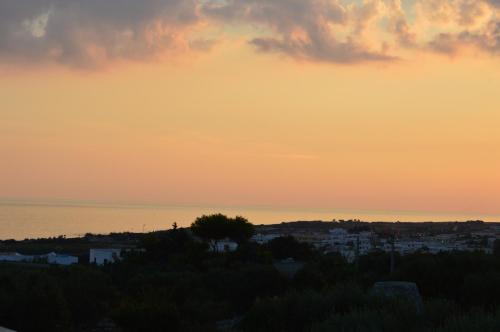 a sunset over the ocean and a city at Villa Bella Vista - VIP by Salento Prime in Marina di Pescoluse