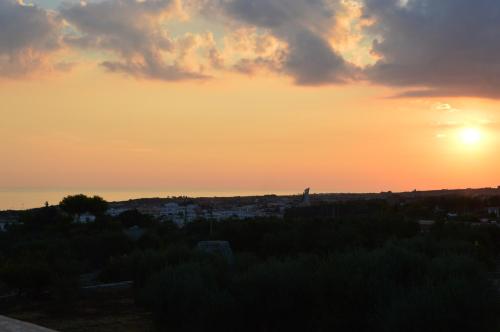a sunset with the sun setting over a city at Villa Bella Vista - VIP by Salento Prime in Marina di Pescoluse