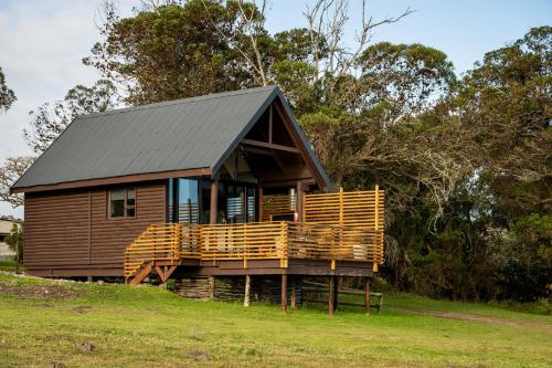a log cabin with a black roof and a deck at Kragga Kamma Game Park in Port Elizabeth