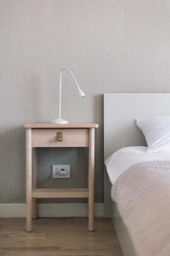 a bedside table with a lamp on it next to a bed at BW Cityline Residences in Belgrade