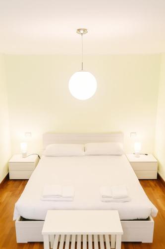 ヴィテルボにあるResidenza la Sapienzaの白いベッドルーム(大きな白いベッド1台、テーブル2台付)