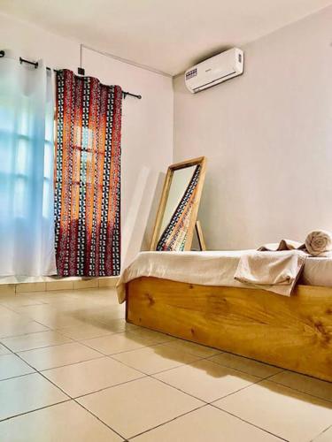 una camera da letto con un letto e una finestra con tende di Lafia Housse a Cotonou