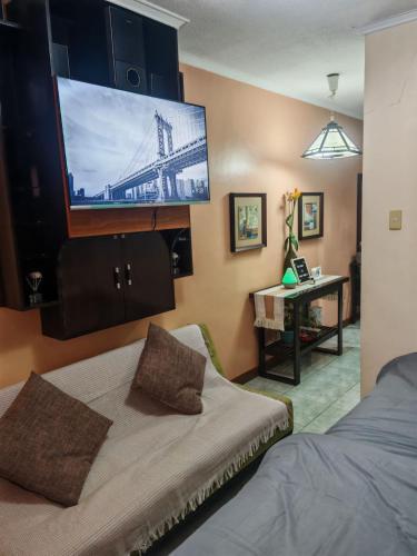 Un dormitorio con televisión, una cama y un escritorio. en Cozy Condo in Baguio, en Baguio