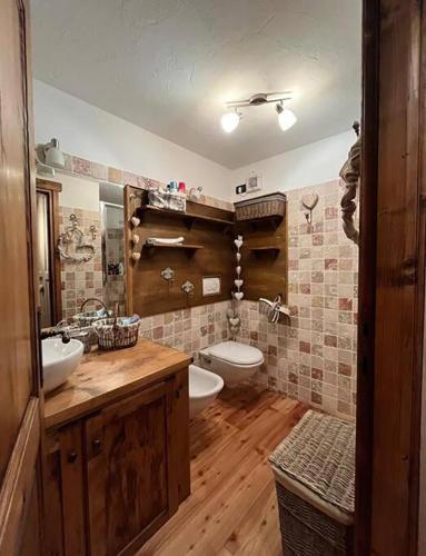 a bathroom with a toilet and a sink and a tub at La casetta del cuore tra terme e montagna in Pré-Saint-Didier