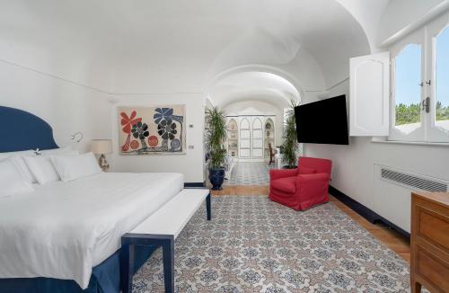 a bedroom with a large bed and a red chair at Villa Treville in Positano