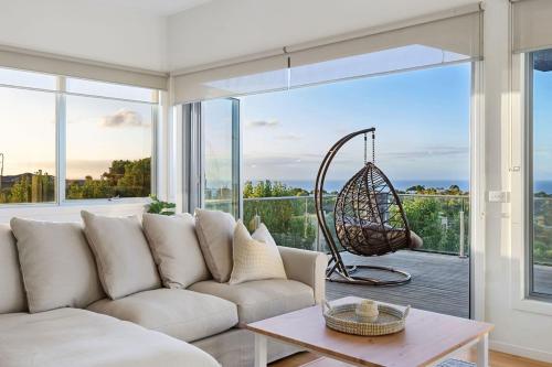 Una sala de estar con un sofá y una ventana grande. en Family Holiday Retreat - Pool & Bay Views, en Mount Martha
