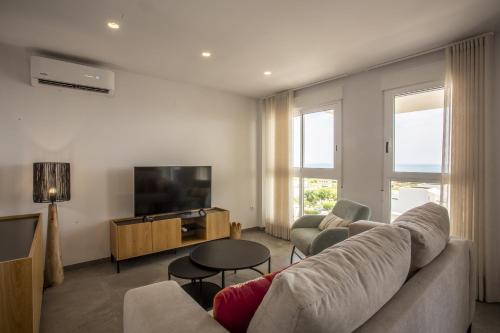 un salon avec un canapé et une télévision dans l'établissement AT Ponent V, à La Playa de la Torre de Piles