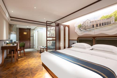 a bedroom with a large white bed and a desk at Nostalgia S Hotel Shanghai Railway Station & Suzhou Creek 时光漫步S酒店上海火车站苏州河店 Free fresh ground coffee,Free laundry service in Shanghai