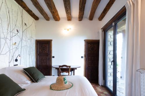 Un dormitorio con una cama blanca y una mesa. en Le Paradis de Lucile, vue de rêve, Giverny 10 minutes, en La Roche-Guyon