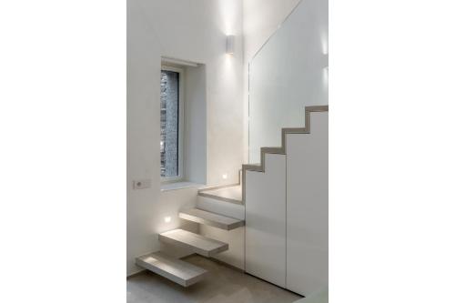 a staircase in a white room with a window at Via dei Monti in Nesso