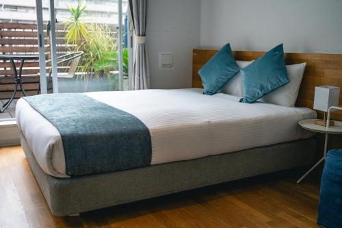 a bedroom with a large bed with blue pillows at UNPLAN Kagurazaka in Tokyo