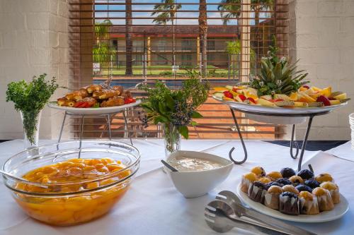 Mildura Inlander Resort في ميلدورا: طاولة مليئة بأواني الفاكهة وأطباق الطعام