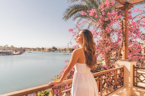 a woman in a white dress looking out over the water at Hotel Sultan Bey Resort in Hurghada