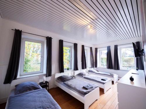 a bedroom with three beds and windows in it at Monteurwohnung-fuer-8-Personen-in-Guelzow-WLAN-Aufenthaltsraum-Parkplatz-Naehe-Hamburg-RZ02a in Gülzow