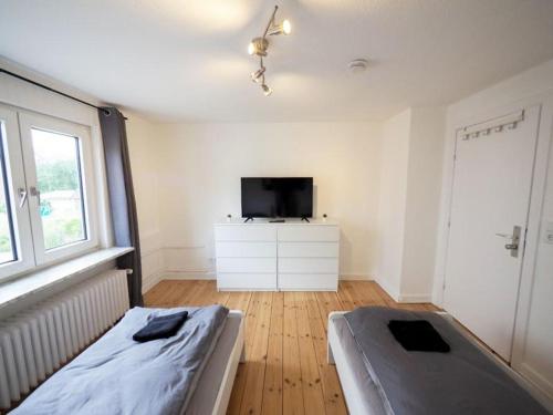 a bedroom with a bed and a flat screen tv at Monteurwohnung-fuer-6-Pers-mit-WLAN-Kueche-TV-Bad-Oldesloe-Naehe-Hamburg-Naehe-Luebeck in Bad Oldesloe