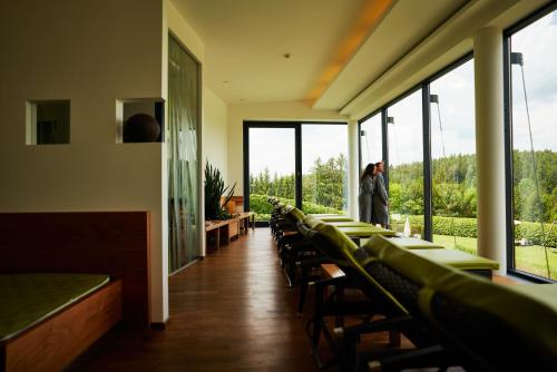 a row of tables and chairs in a room with windows at Hotel Schwarz Alm Zwettl in Zwettl Stadt