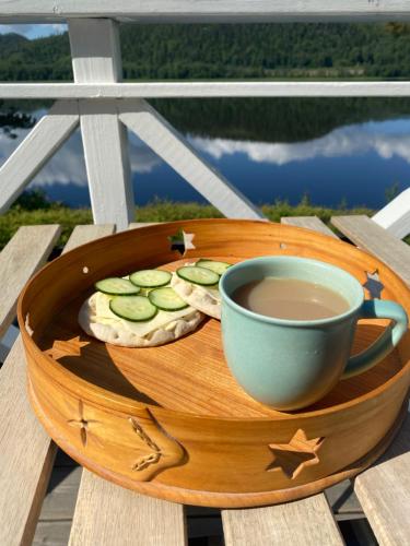 a wooden tray with a cup of tea and cookies at The Riverside in Undrom