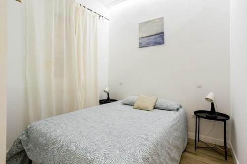 - une chambre blanche avec un lit et deux lampes dans l'établissement Apt temporada Gta Embajadores Centro Arganzuela, à Madrid