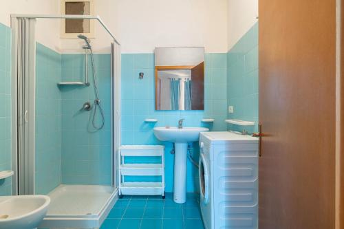 a blue bathroom with a sink and a shower at Casa Patrizia in centro a Marzamemi in Marzamemi
