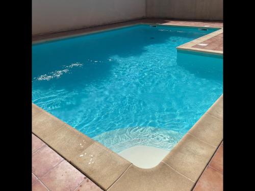 - une piscine avec une chaise dans l'eau dans l'établissement Les 3 Ondes - Avec terrasse, à Agde