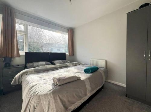a bedroom with a large bed with a large window at 3bed house Brighouse - working professionals welcome FREE parking & WI-FI in Brighouse