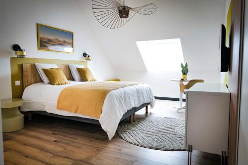 a bedroom with a bed and a table and a window at L'Escapade d'Acquigny, Piscine, Foot Five, Salle de sport, BabyFoot in Acquigny