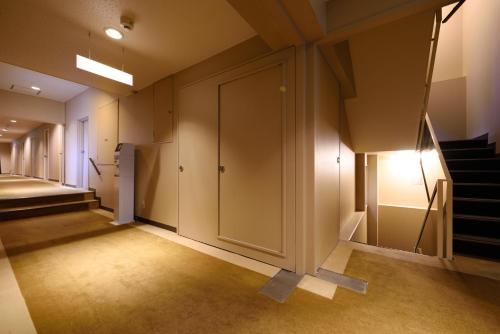 a hallway with a door and stairs in a building at Morioka City Hotel in Morioka