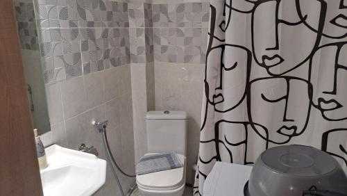 een badkamer met toilet en douchegordijn bij Paulos Apartment in Pefkochori