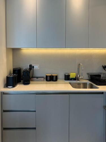 a kitchen counter with white cabinets and a sink at BW Cityline Residences in Belgrade