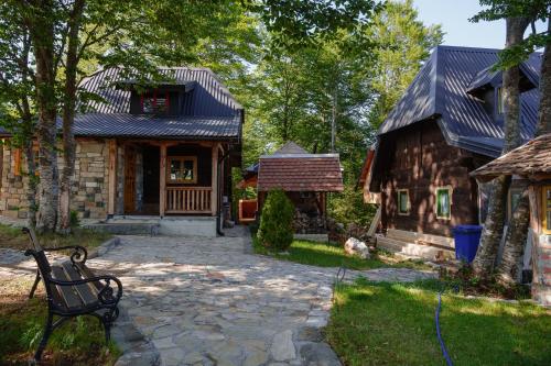 a house with a bench in front of a building at Brvnara Iverak in Mokra Gora