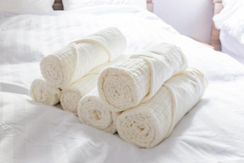 a pile of rolled towels on a bed at Sakuramachi Villa Projector BBQ Free parking 2 Bed Rooms in Kumamoto