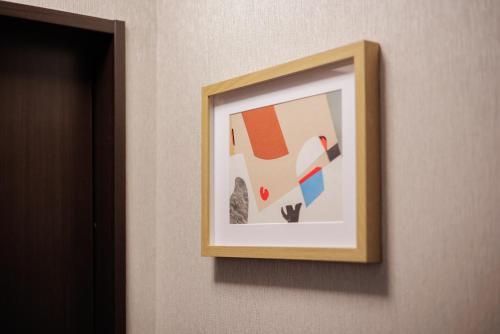 a picture hanging on a wall in a room at Sakuramachi Villa Projector BBQ Free parking 2 Bed Rooms in Kumamoto