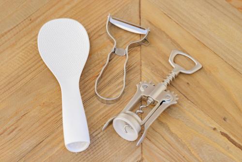 a white spoon and a white spatula on a wooden floor at Sakuramachi Villa Projector BBQ Free parking 2 Bed Rooms in Kumamoto