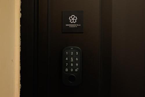 a close up of a remote control on a black door at Sakuramachi Villa Projector BBQ Free parking 2 Bed Rooms in Kumamoto
