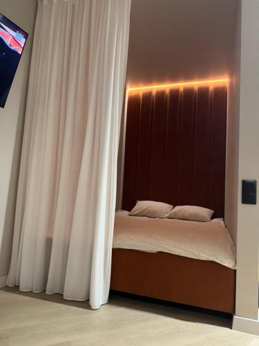 a bed in a room with a curtain at Неймовірно крута студія в центрі Черкас! Панорамні вікна! Ремонт 2025 року in Cherkasy