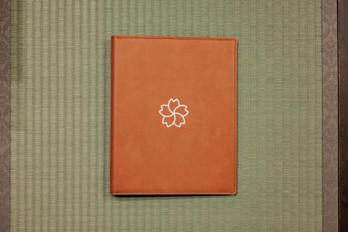 a brown book with a flower on it at Sakuramachi Villa Projector BBQ Free parking 2 Bed Rooms in Kumamoto