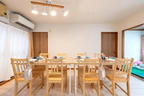a dining room with a wooden table and chairs at HIKONE-Step 彦根ステップ 彦根駅徒歩4分 軽自動車用無料駐車場 彦根城徒歩15分 15名まで 戸建貸切 in Hikone