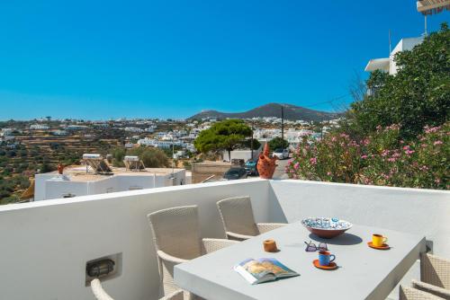 a table and chairs on a balcony with a view at Sifnos Hideaway in Sifnos