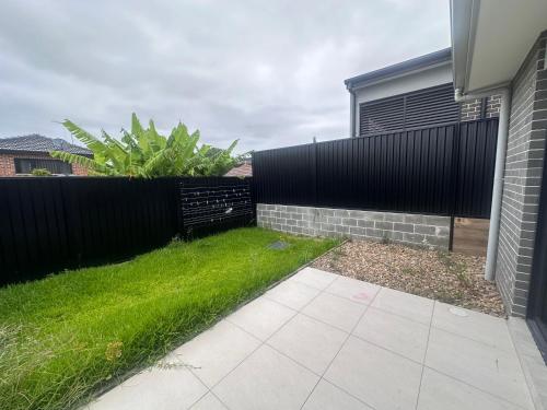 a backyard with a fence and green grass at Queen Room in Modern, Guildford House - OR7 in Guildford