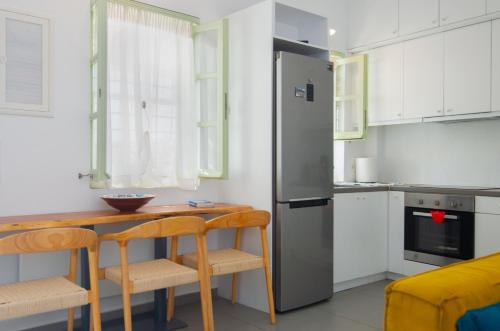 a kitchen with a wooden table and a refrigerator at Sifnos Hideaway in Sifnos