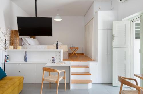 a living room with white walls and a white table and chairs at Sifnos Hideaway in Sifnos