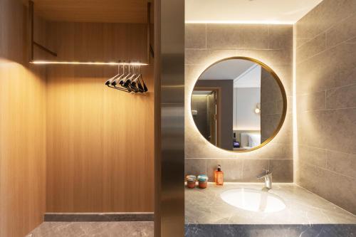 a bathroom with a sink and a mirror at Orange Hotel Beijing Yizhuang Bridge Subway Station in Beijing