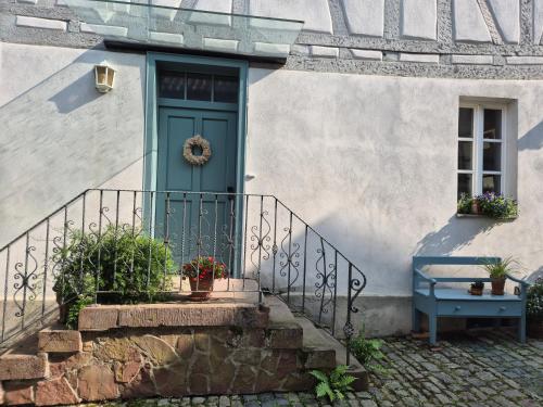 eine Tür eines weißen Hauses mit einer blauen Tür in der Unterkunft Wengertshaus in Hammelburg