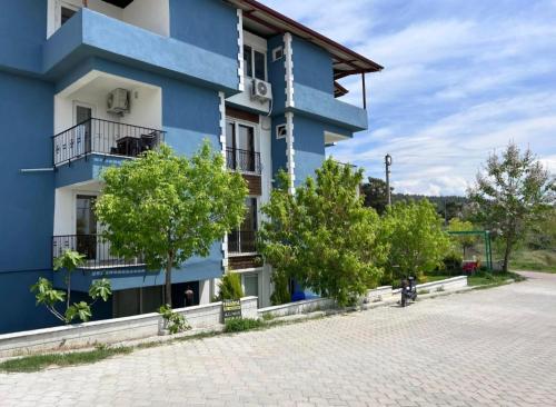 a blue building with trees in front of it at Paradise House in Pamukkale