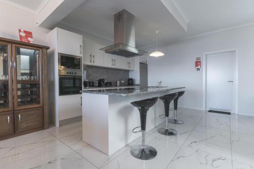 a kitchen with a large island in the middle at Blue Outlook Retreat by Atlantic Holiday in Água de Pena
