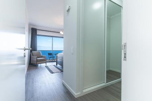 a room with a glass door leading to a living room at Blue Outlook Retreat by Atlantic Holiday in Água de Pena