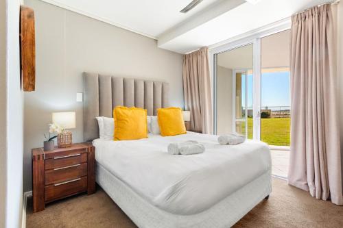 a bedroom with a large bed and a window at Lagoon Beach 29A by Host Agents in Cape Town