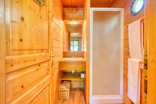 - une salle de bains pourvue d'un lavabo dans une cabine en bois dans l'établissement La Roulotte Jaune, à Monsac