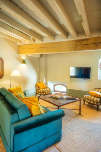 a living room with a blue couch and a table at Le Domaine de Richebourg - Pierres d'Histoire in Richebourg