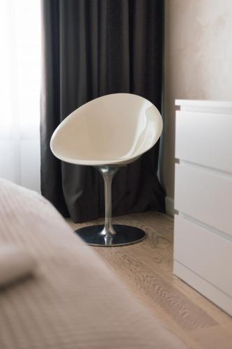 a white chair sitting next to a dresser in a bedroom at BW Cityline Residences in Belgrade